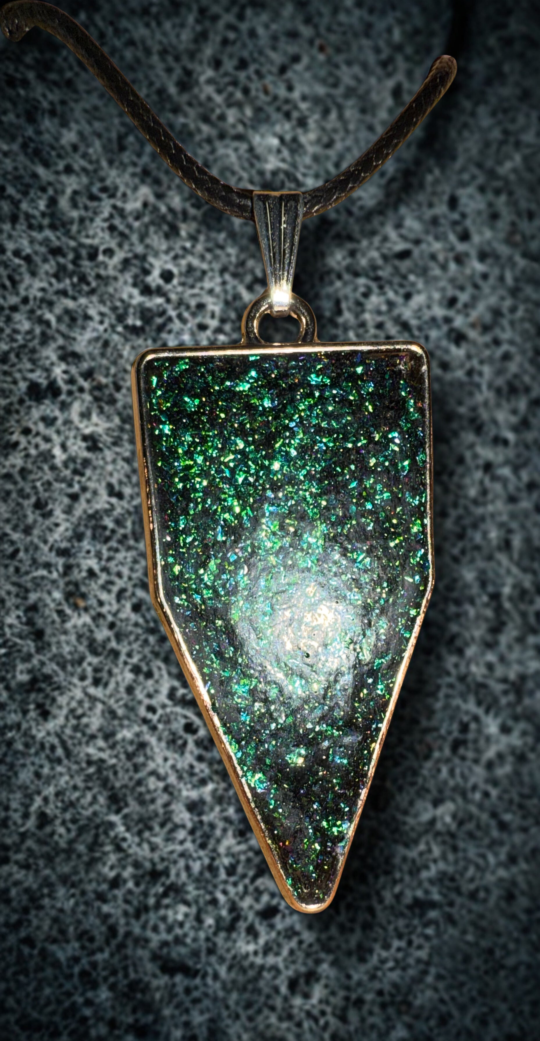 triangular pendant set in a polished bronze-toned bezel